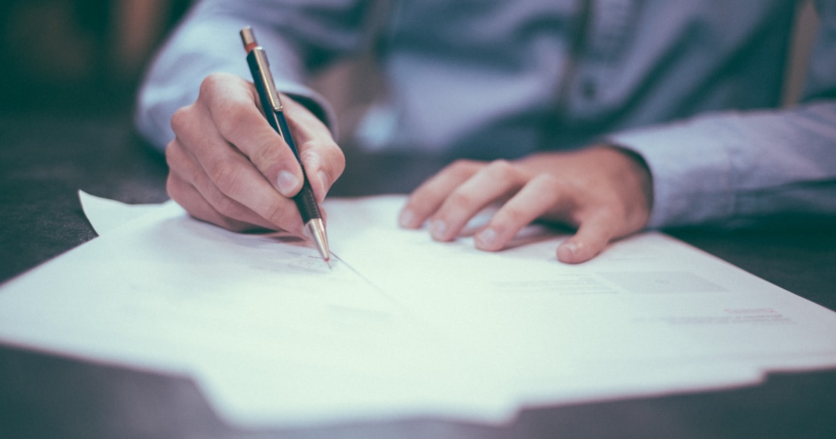 Signature de documents officiels symbolisant une démarche de certification
