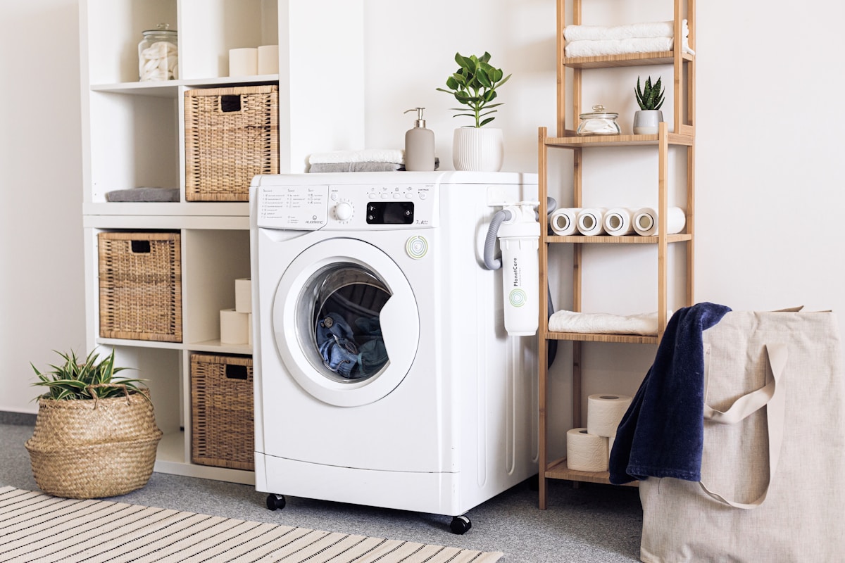 Technicien réparant un lave-linge dans une cuisine